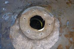 During a rebuild this small bottom drain was replaced. The underlayment was not trimmed away, preventing a water tight seal